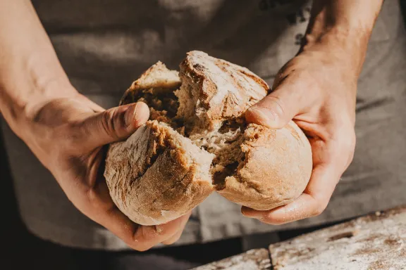 Man breaking fresh bread image
